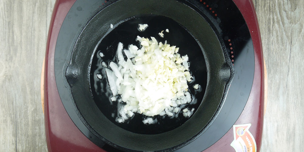 平底鍋倒油將洋蔥和蒜頭拌炒至金黃後倒入醬油