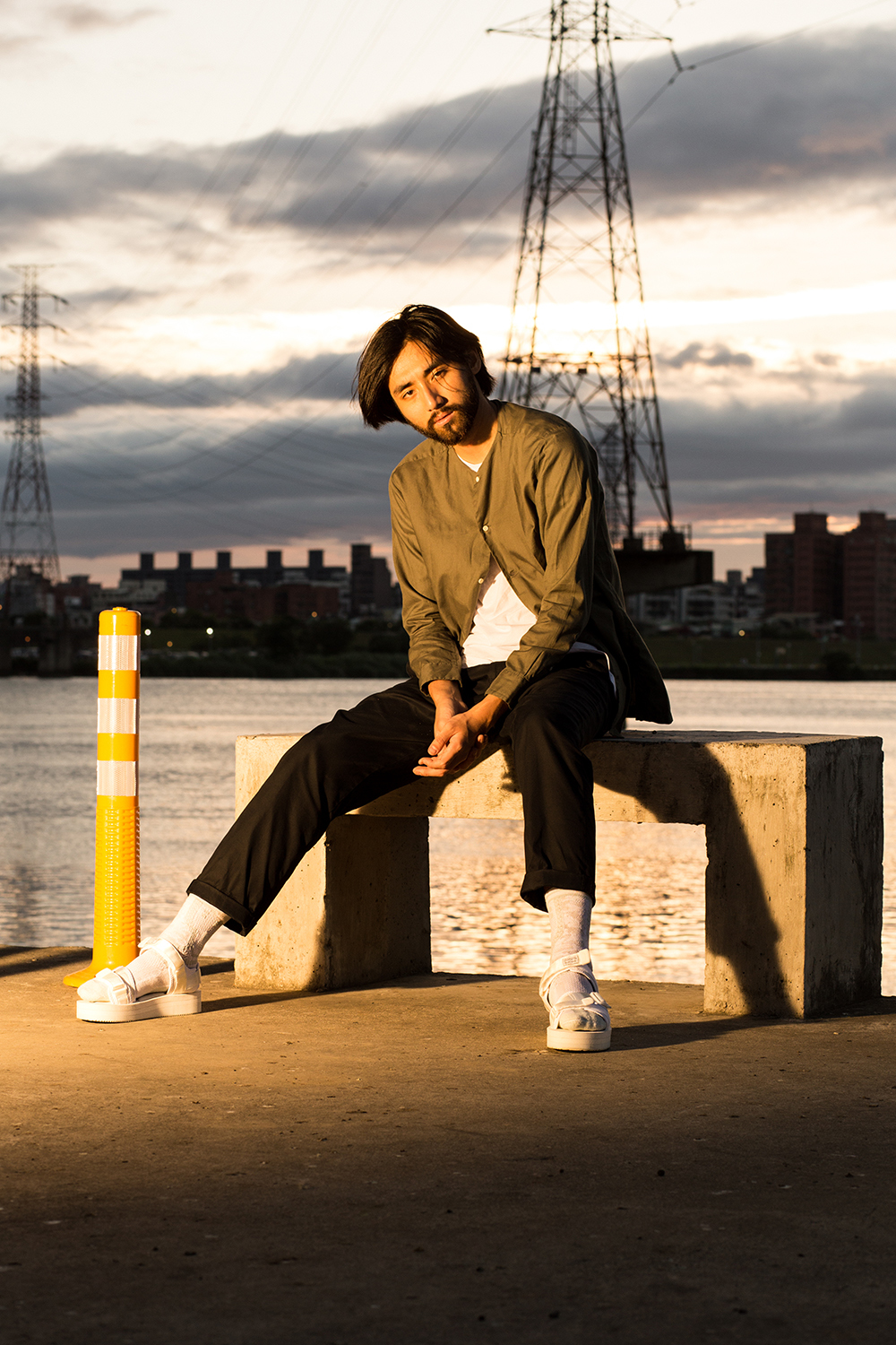 機能襪履設計品牌 nozzle quiz 經典"STREET AGILITY" 系列 lookbook，搭配suicoke的白色涼鞋與純白網眼編織長襪，魔幻時光的黃昏下，閃耀著粼粼波光的河岸，即使在都市中，男子有著自己的步調與空間。