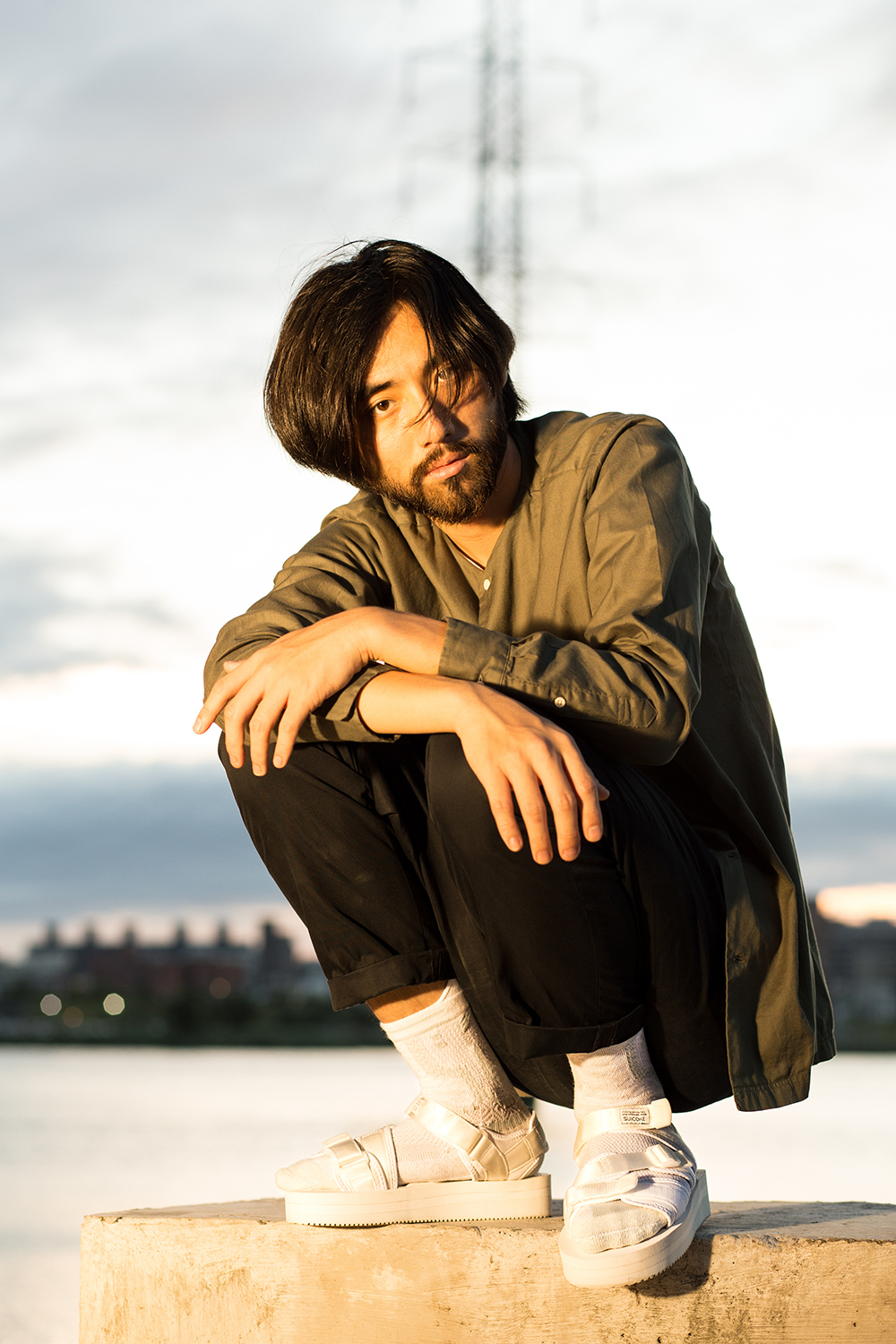 機能襪履設計品牌 nozzle quiz 經典"STREET AGILITY" 系列 lookbook，搭配suicoke的白色涼鞋與純白網眼編織長襪，魔幻時光的黃昏下，閃耀著粼粼波光的河岸，即使在都市中，男子有著自己的步調與空間。