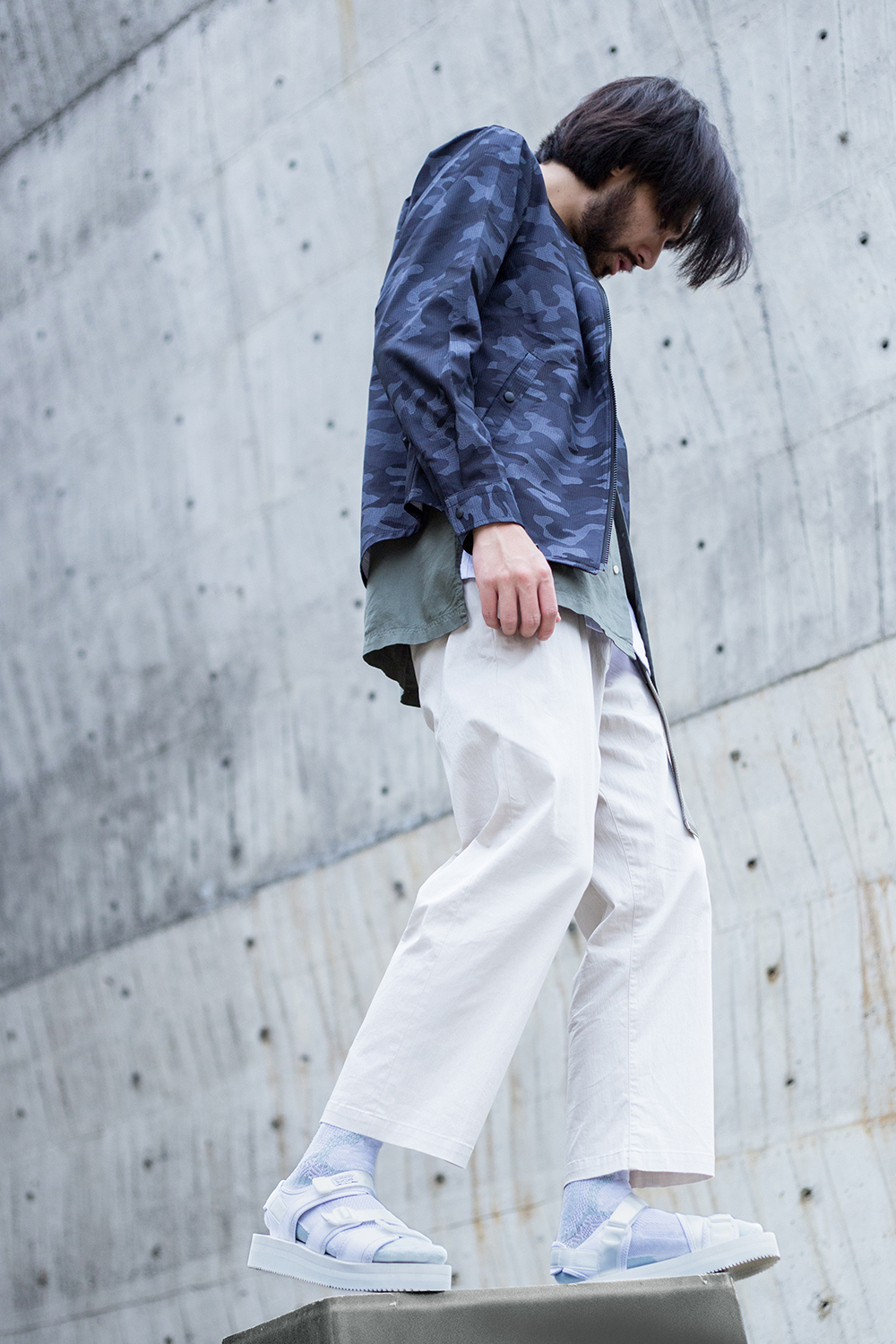 機能襪履設計品牌 nozzle quiz 經典"STREET AGILITY" 系列 lookbook，清爽中帶著日系休閒個性的迷彩紋外套，搭配suicoke的白色涼鞋與純白網眼編織長襪。細節佐以加長尼龍腰帶作為一點調皮地展現。