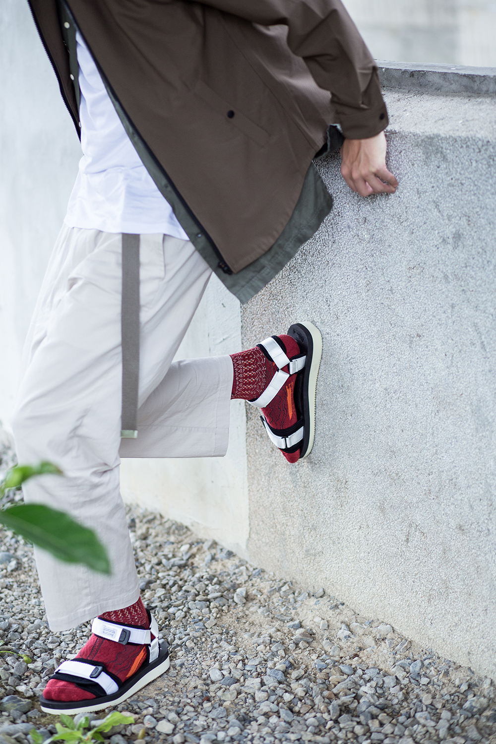 機能襪履設計品牌 nozzle quiz 經典"STREET AGILITY" 系列 lookbook，suicoke的白色涼鞋有著絕佳的百搭特性，紅色編織長襪顯示出你不安分的穿著玩心。