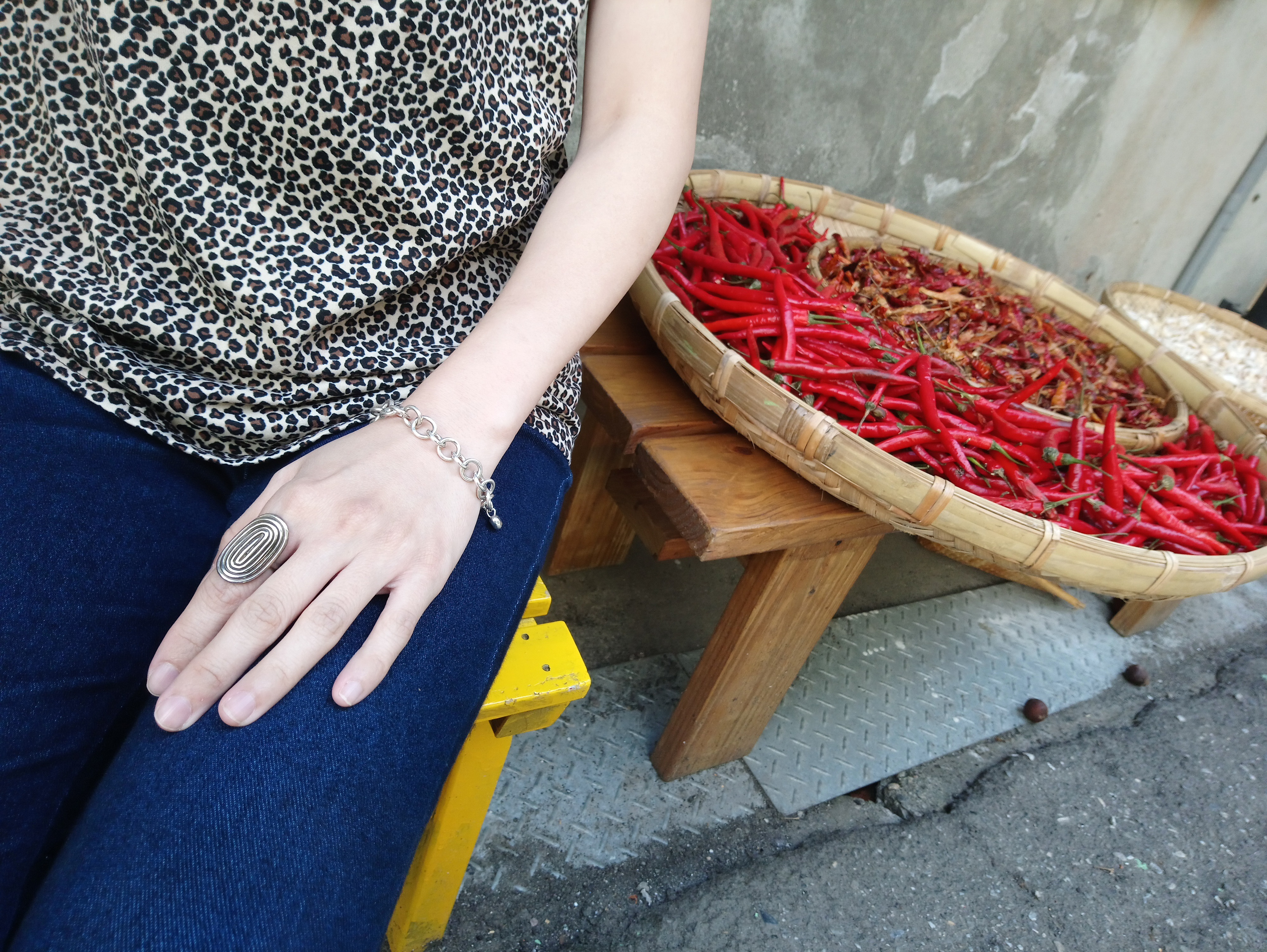 巷弄邊的小店門口曬著辣椒而坐在旁邊的旅客正享受著初秋的陽光冥想著