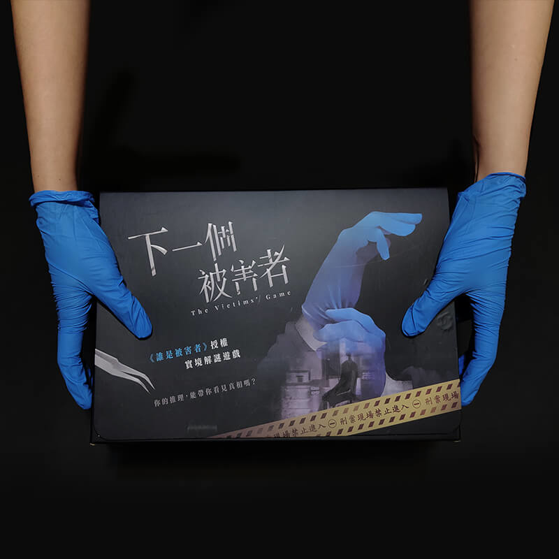 戴著遊戲道具藍手套 拿著 誰是被害者 影集授權 下一個被害者 遊戲盒