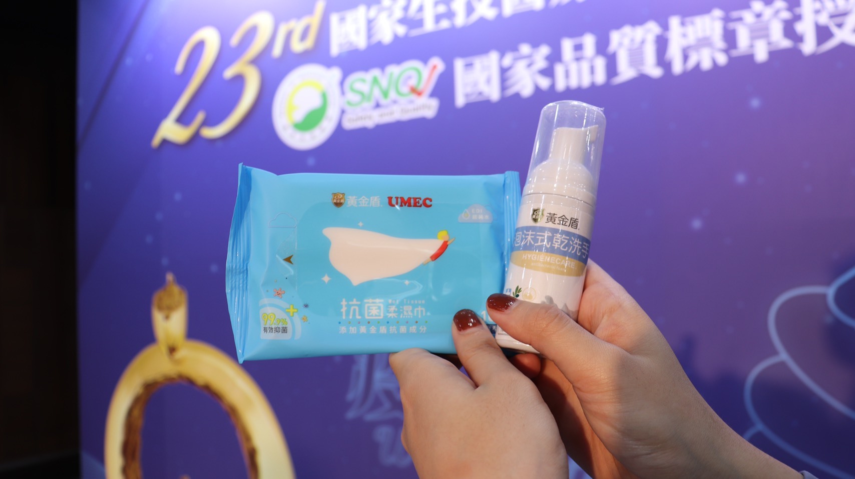 一雙手舉著黃金盾抗菌柔濕巾和泡沫式乾洗手