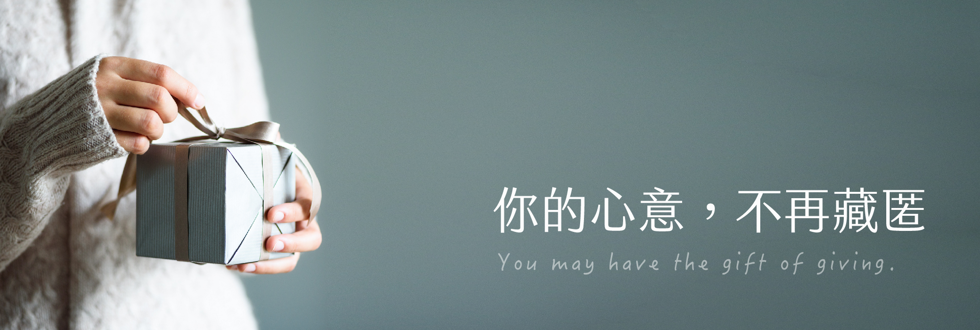 穿著毛衣的人手拿著禮物盒的照片