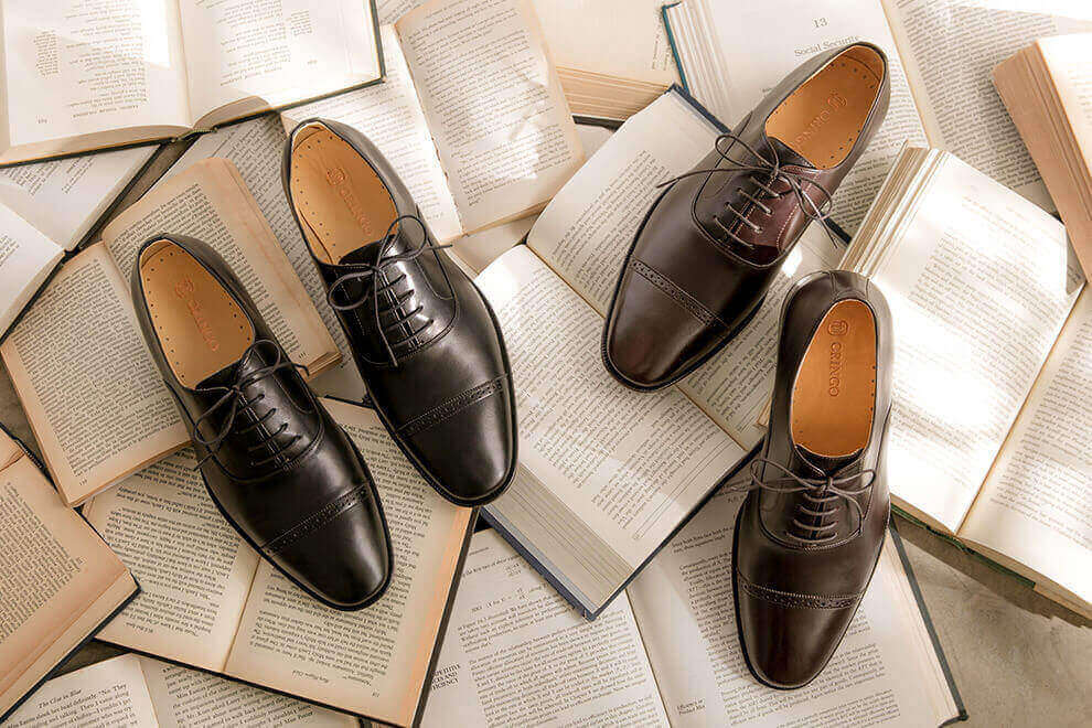 牛津鞋 林果良品 Quarter Brogue 1/4雕花橫飾牛津鞋-濃粹咖色和經典黑色放在展開的英文書上