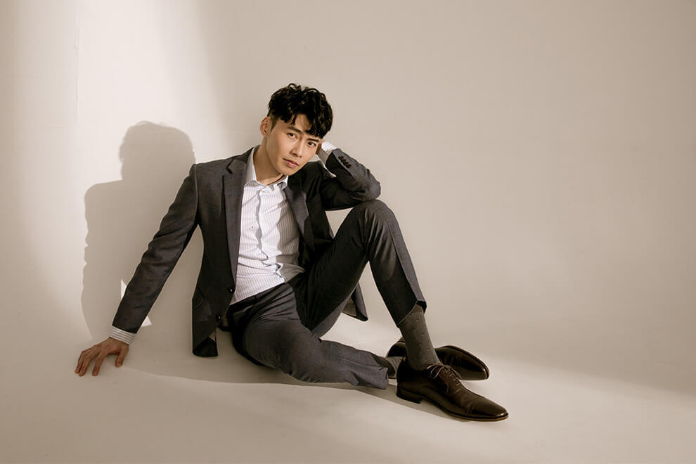 牛津鞋 林果良品 Quarter Brogue 1/4雕花橫飾牛津鞋濃粹咖色 模特坐姿搭配灰色西裝與直條紋襯衫展示照