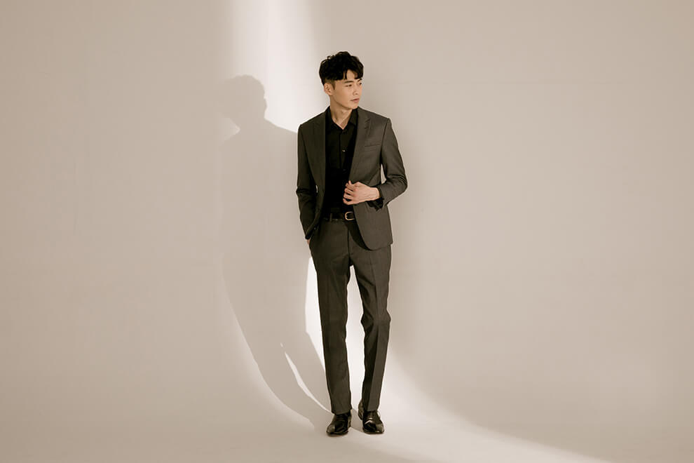 牛津鞋 站立模特穿著黑色襯衫與深灰色西裝搭配林果良品的1/4雕花橫飾經典黑色牛津鞋