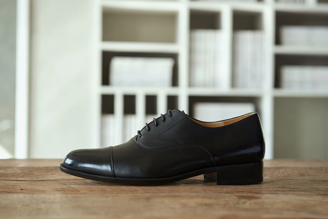 牛津鞋 側面展示桌上的黑色鵝頸橫飾皮底商務牛津鞋