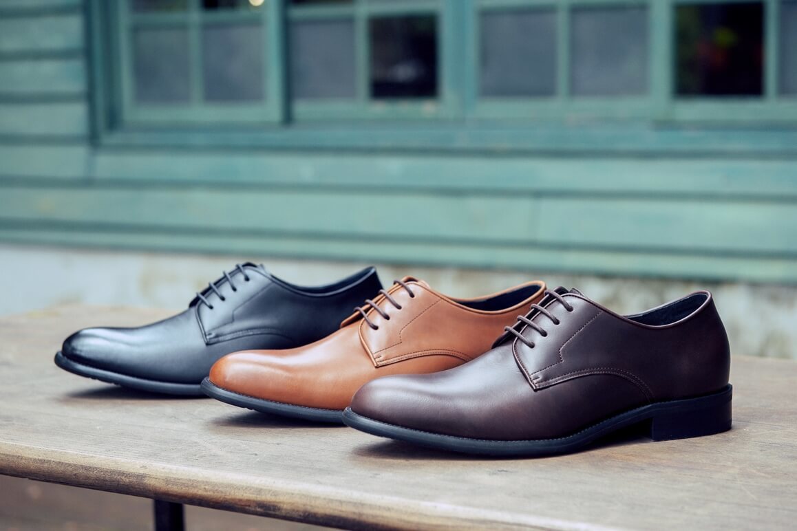 基本款膠底德比鞋黑色、咖啡色、濃淬咖色斜著擺放在綠色窗戶前的木架上