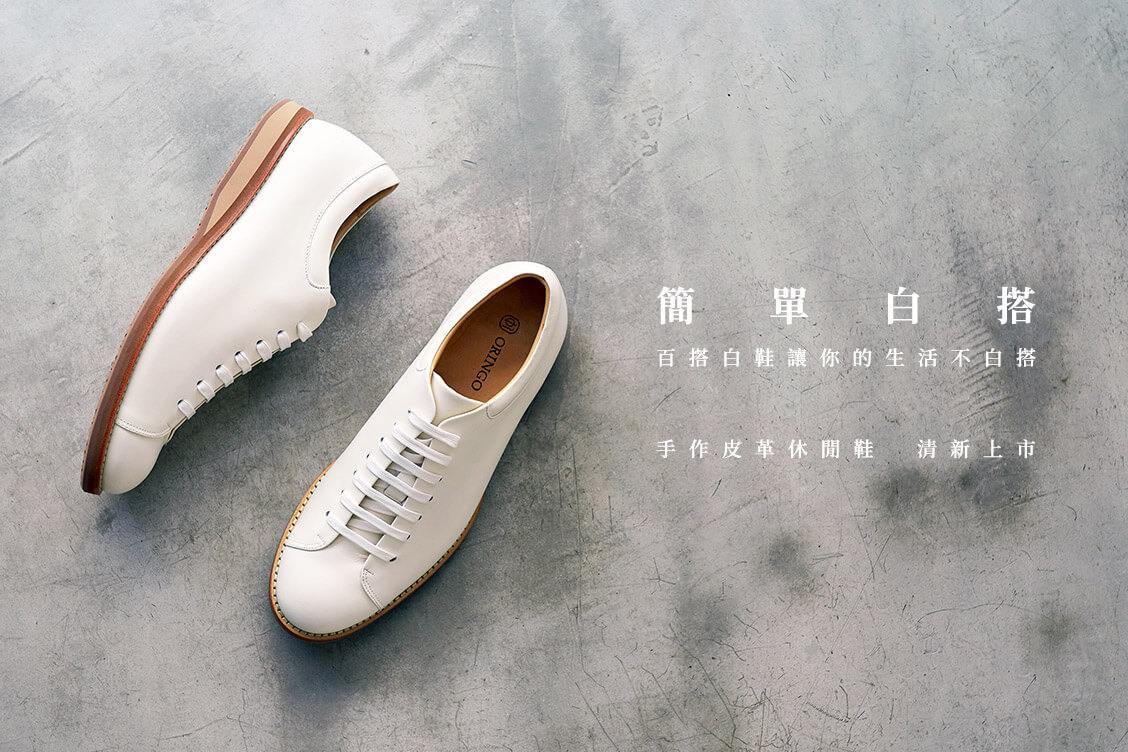 皮革休閒鞋 簡單的皮革小白鞋配上黃色的膠底一正一側展示在灰岩石面上