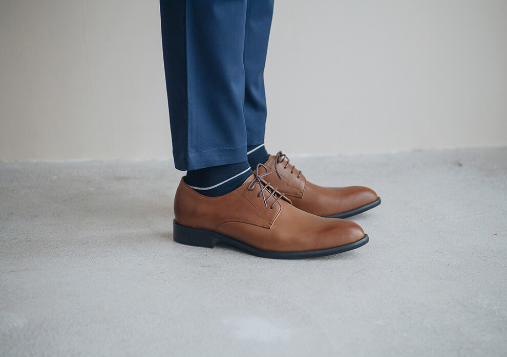 德比鞋 模特兒雙腳併攏特寫湛藍西裝褲與深藍紳士襪搭配上咖啡色德比鞋紳士鞋