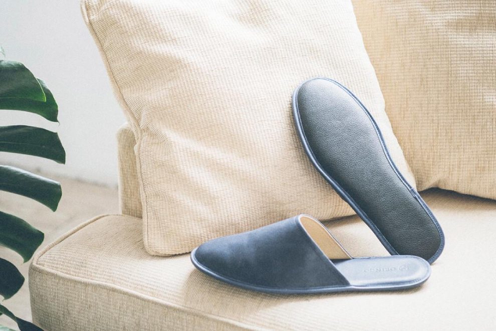 牛皮室內拖鞋 米白色沙發上有一雙湛藍色牛皮拖鞋