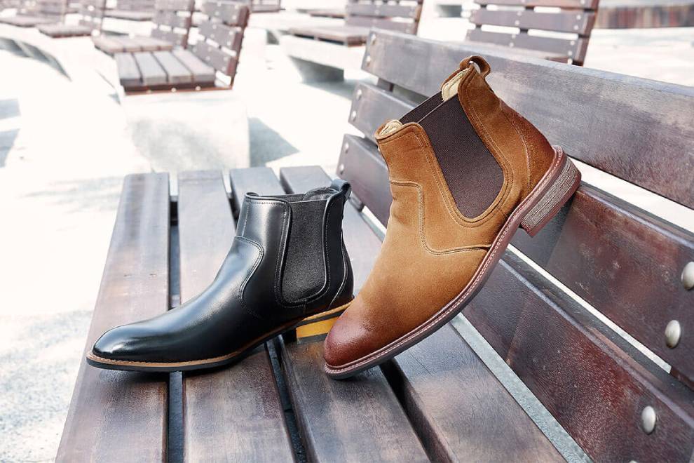 黑色與棕色的卻爾喜膠底靴擺在公園的長椅上