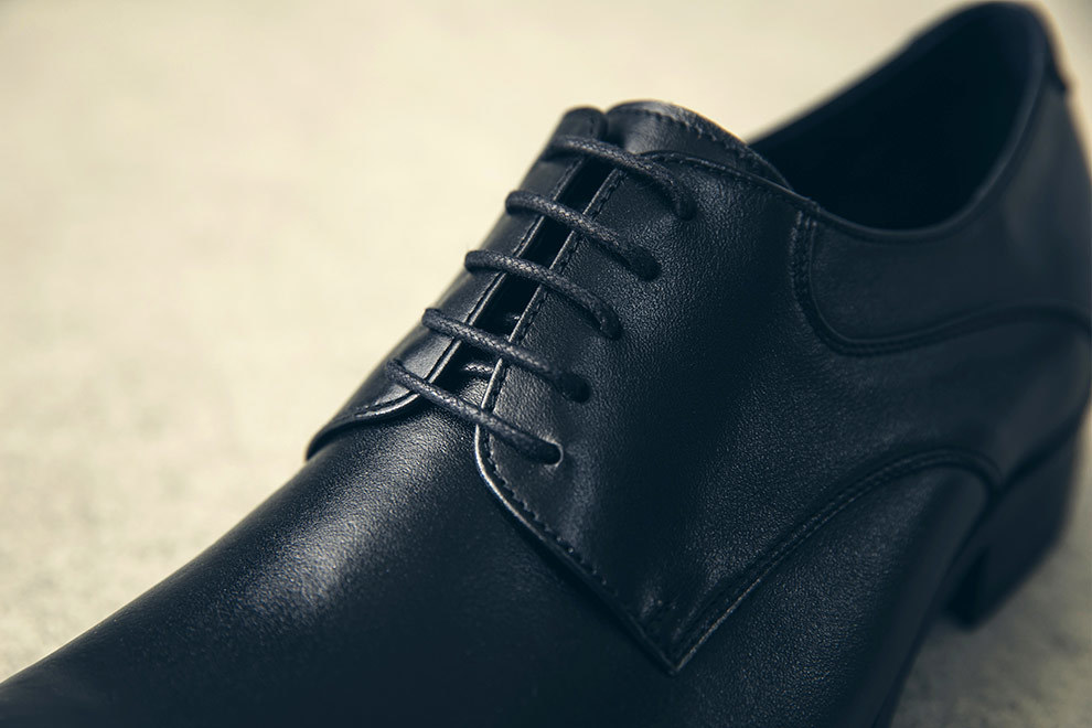 黑色色流線德比鞋開放襟片皮革紋理與鞋帶特寫