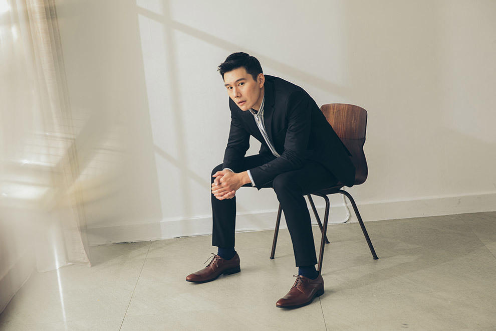 模特穿著黑色商務西裝搭配可可咖啡色經典流線德比鞋