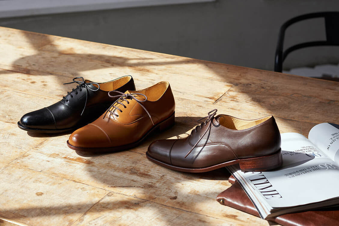 牛津鞋 木桌面上擺著3只商務牛津鞋黑色棕色與咖啡色