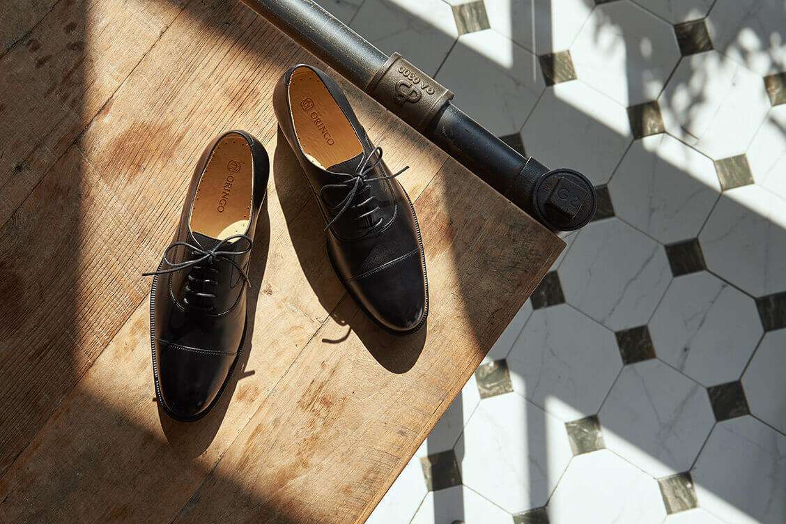 牛津鞋 俯視桌上一雙黑色的鵝頸橫飾商務牛津鞋