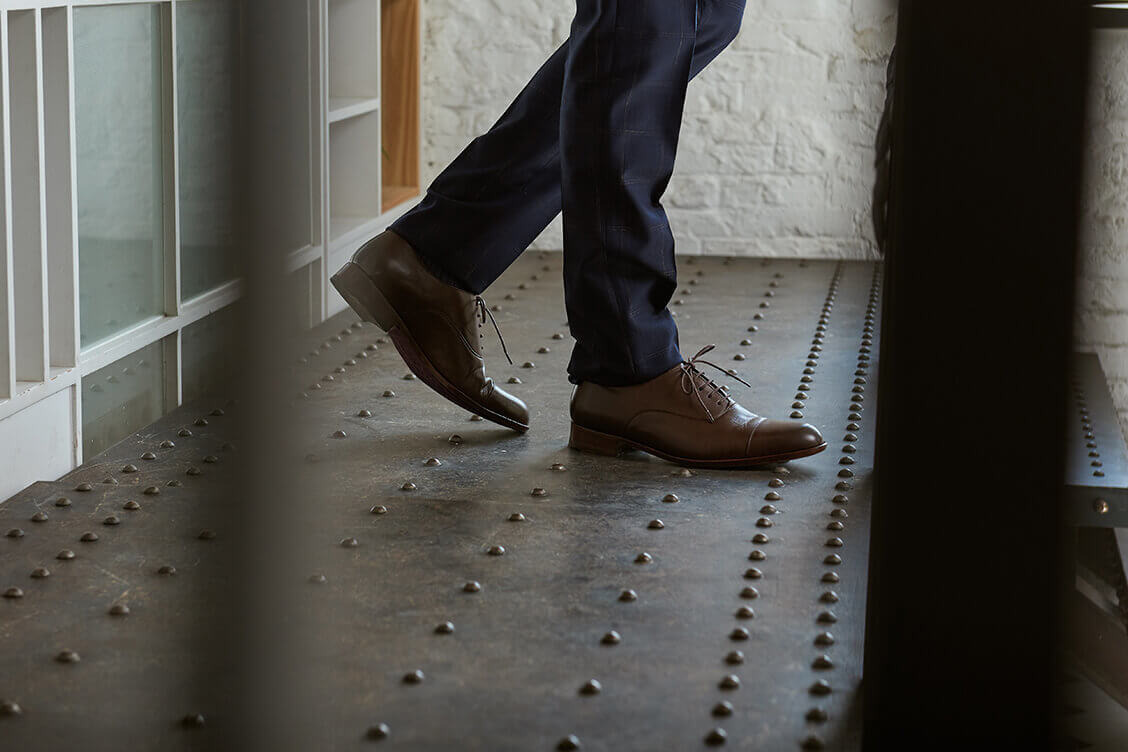 牛津鞋 特寫模特深藍色西裝褲搭配咖啡色商務牛津鞋