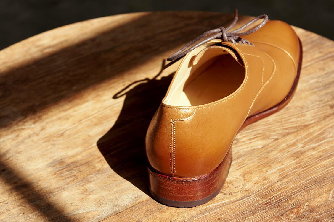 蜜糖租棕色的鵝頸橫飾商務牛津鞋後跟特寫