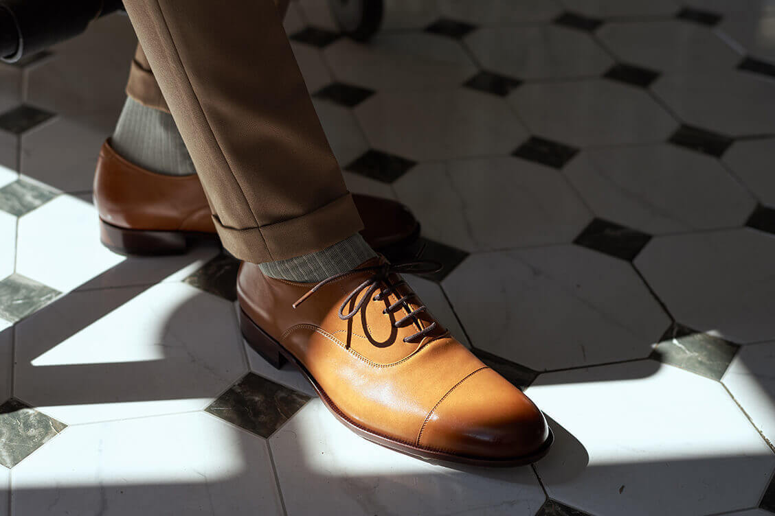 特寫模特展示卡其褲搭配蜜糖棕色的牛津鞋