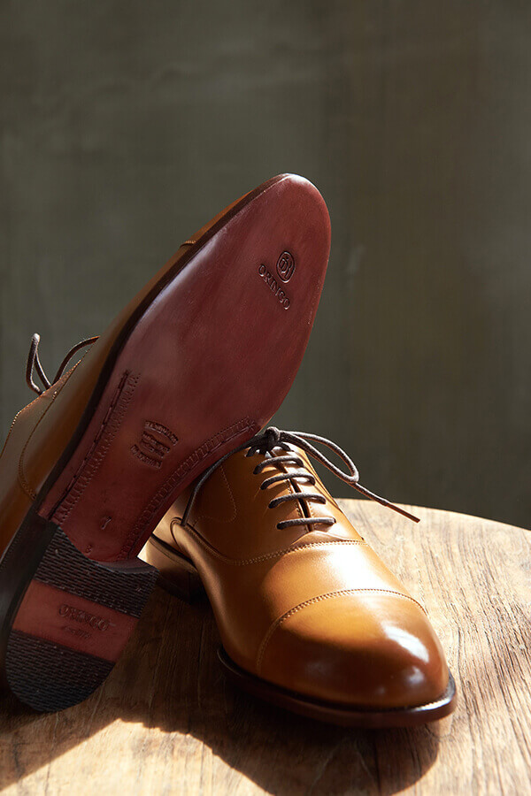 展示蜜糖棕色鵝頸橫飾商務牛津鞋的皮底鞋底