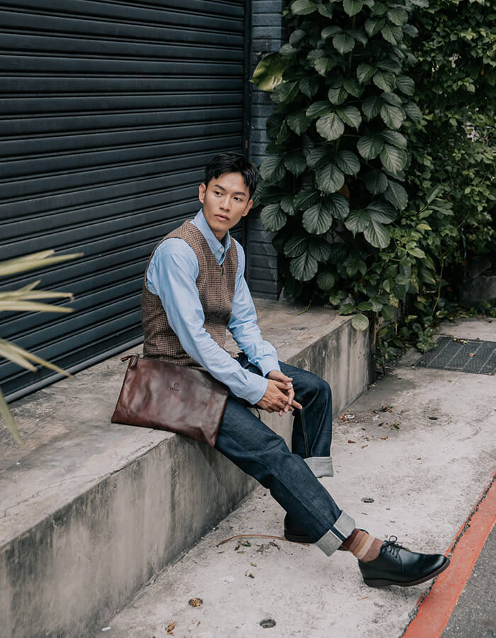 休閒商務德比鞋 穿著牛仔褲搭配黑色德比紳士鞋的模特坐在石階上