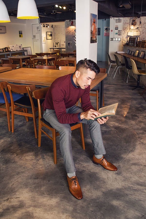 穿著酒紅毛衫與灰色西裝褲的模特搭配蜜棕色牛津鞋