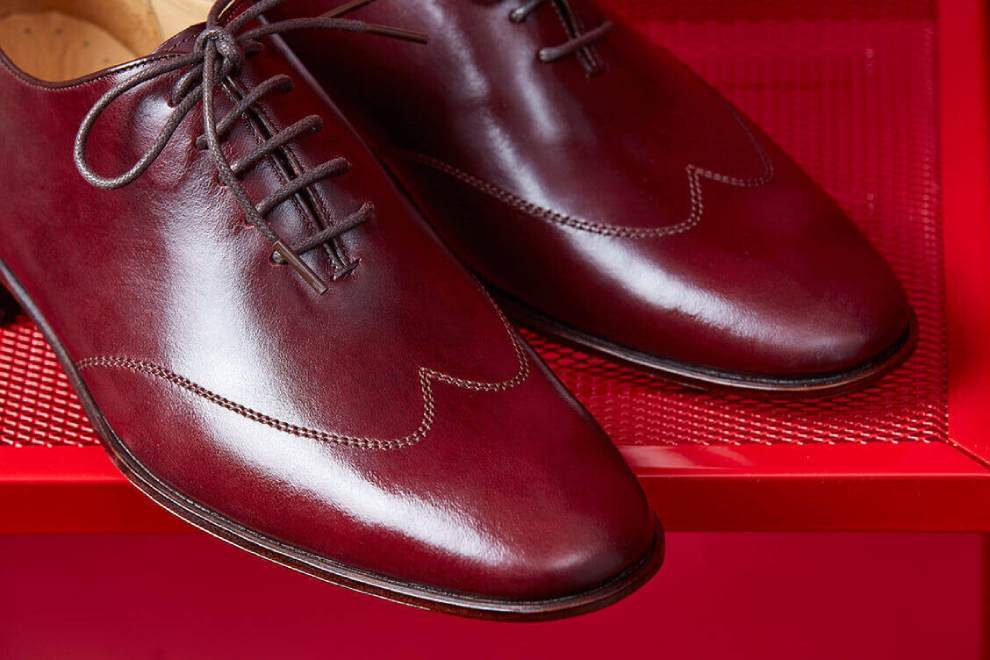 特寫酒紅色牛津鞋鞋頭翼紋縫線與油感皮料色澤