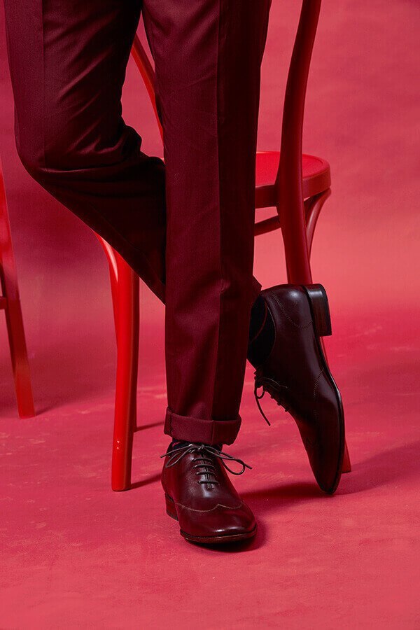 特寫酒紅色西裝搭配酒紅色全裁片皮底翼紋牛津鞋
