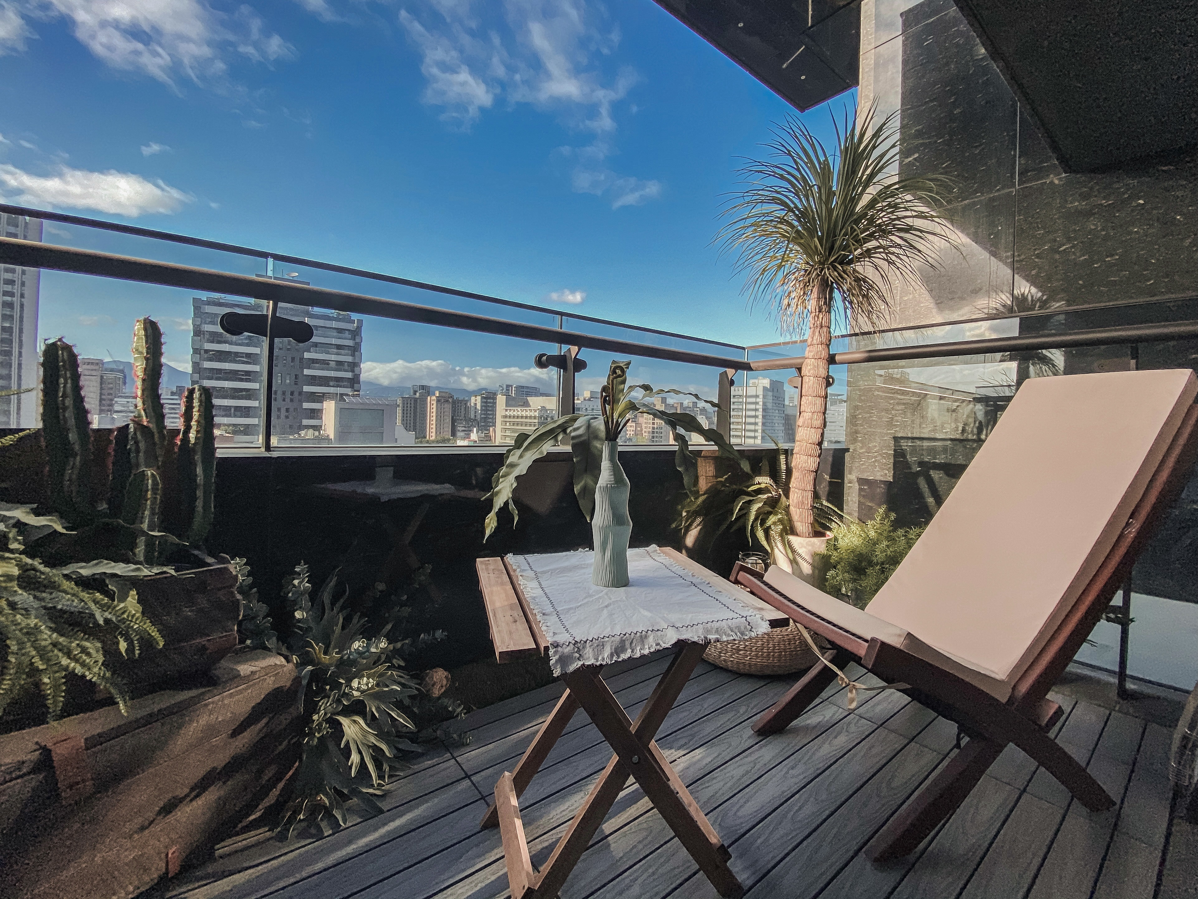 陽台有躺椅跟小木桌及數個綠色盆栽