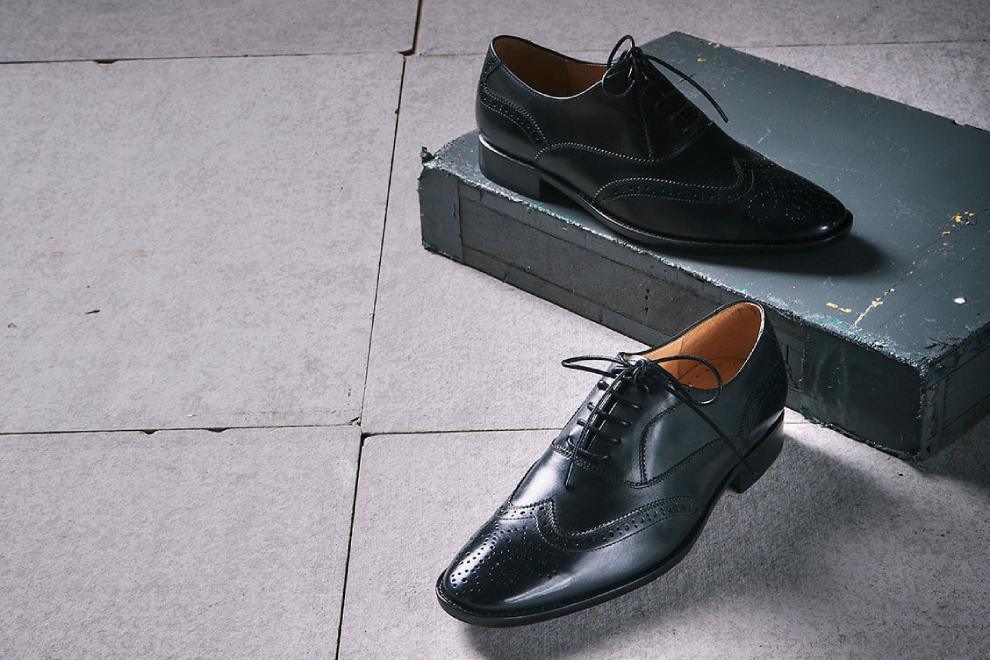牛津鞋 展示經典黑色3/4雕花鋸齒翼紋牛津鞋鞋光線下的皮革光澤