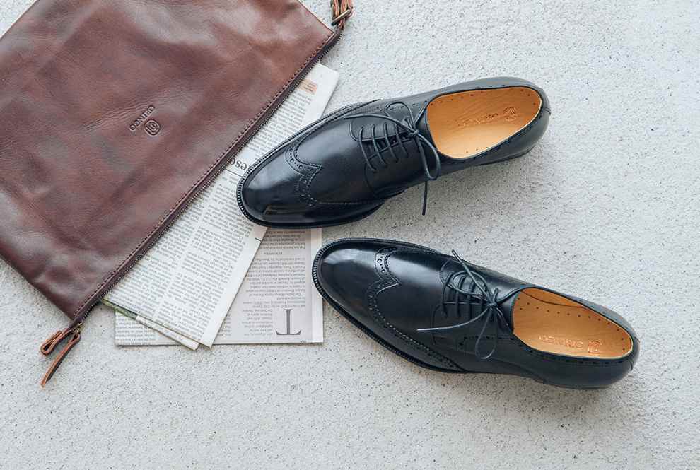 經典黑色的翼紋雕花德比鞋與煙棕色的皮革手拿包