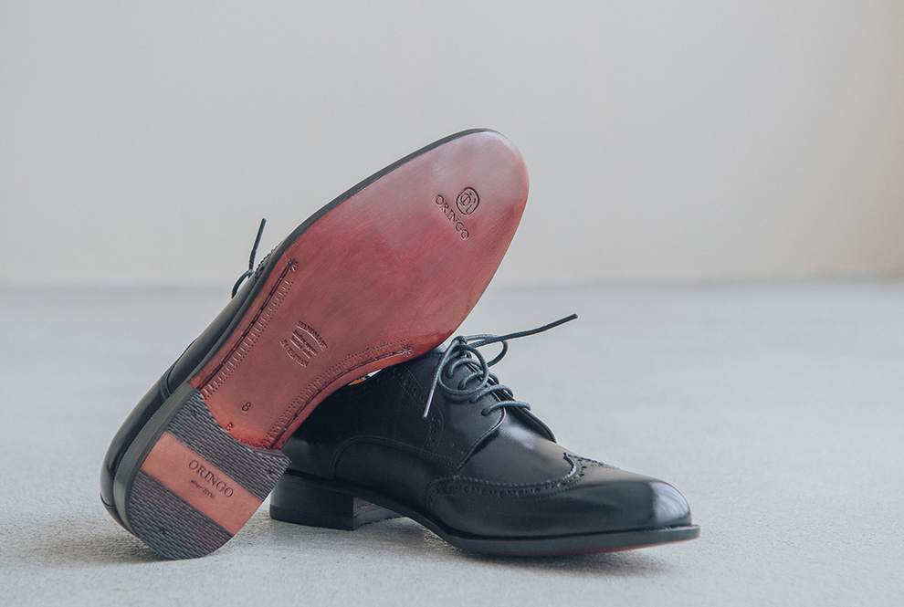 展示經典黑色的翼紋雕花德比鞋皮革鞋底與木跟