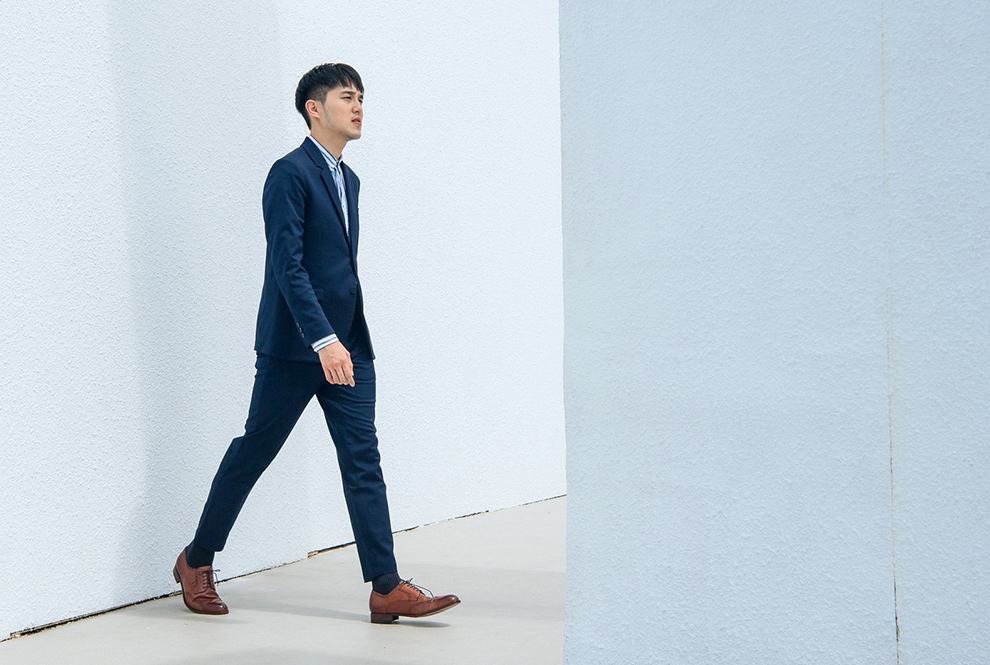 德比鞋 深藍色成套西裝的模特搭配上焦糖棕色的翼紋雕花德比鞋