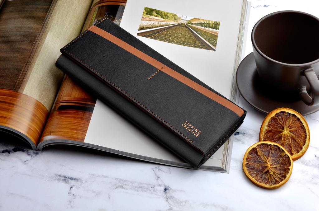 俬品創意,紙革長夾咖啡黑放於雜誌上