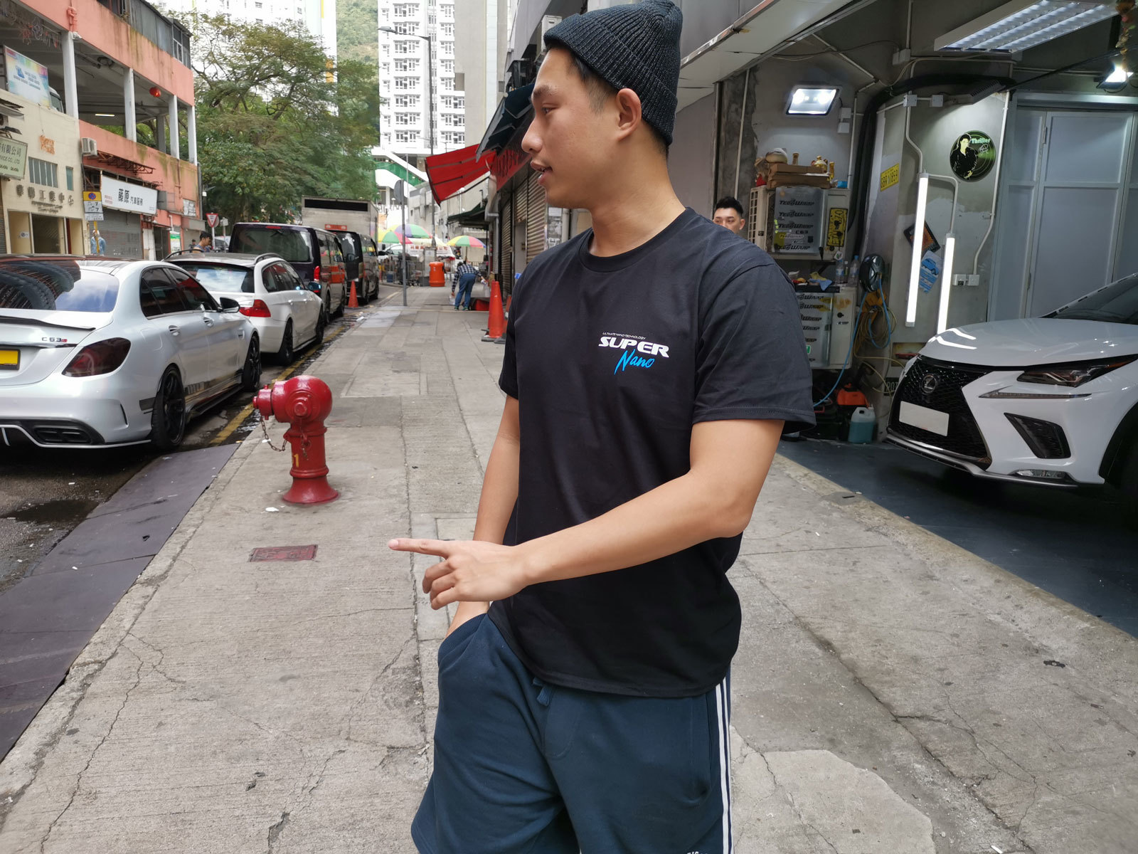 will tam standing outside garage wearing black super nano t shirt