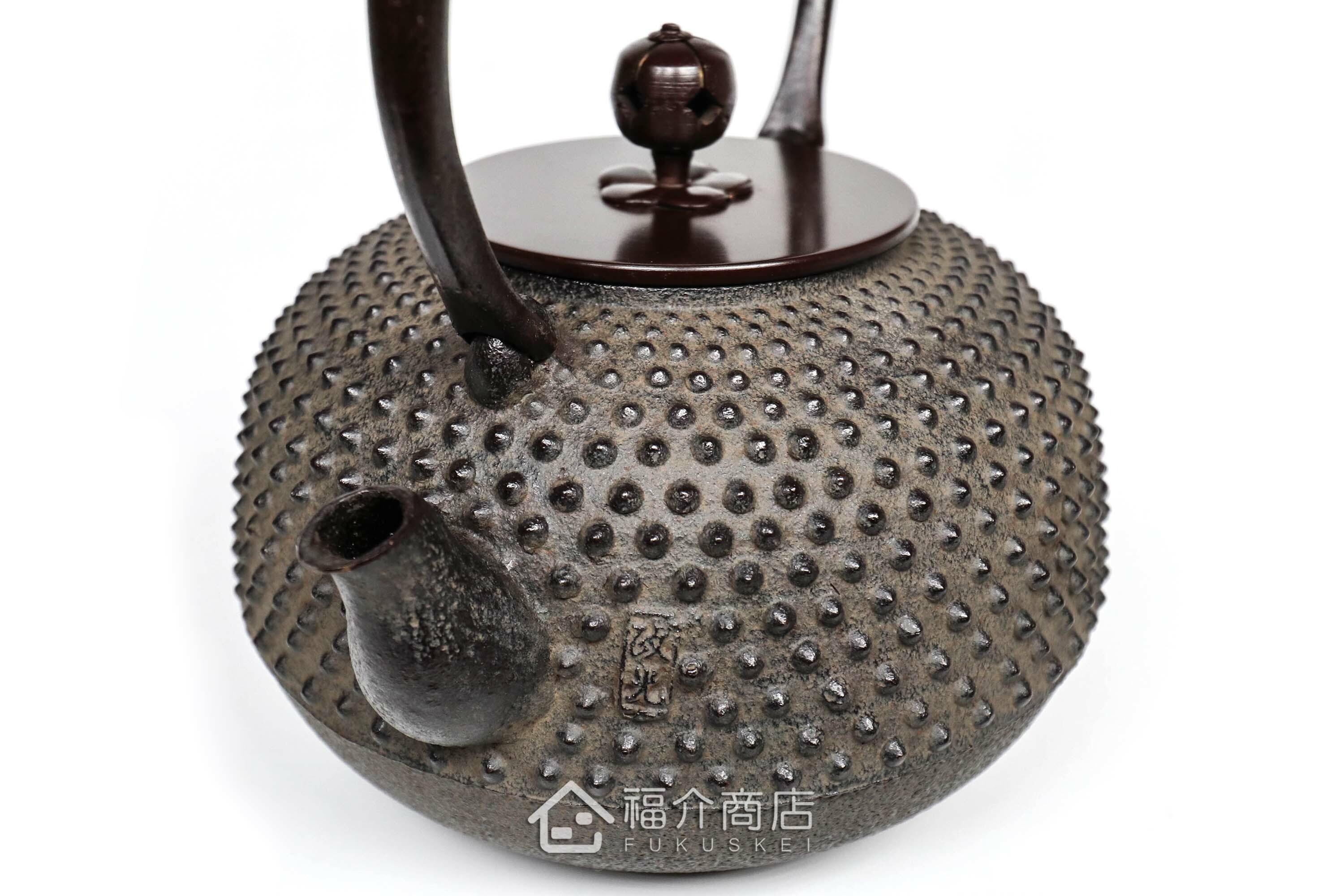 黑色鐵壺的壺嘴旁有作者落款