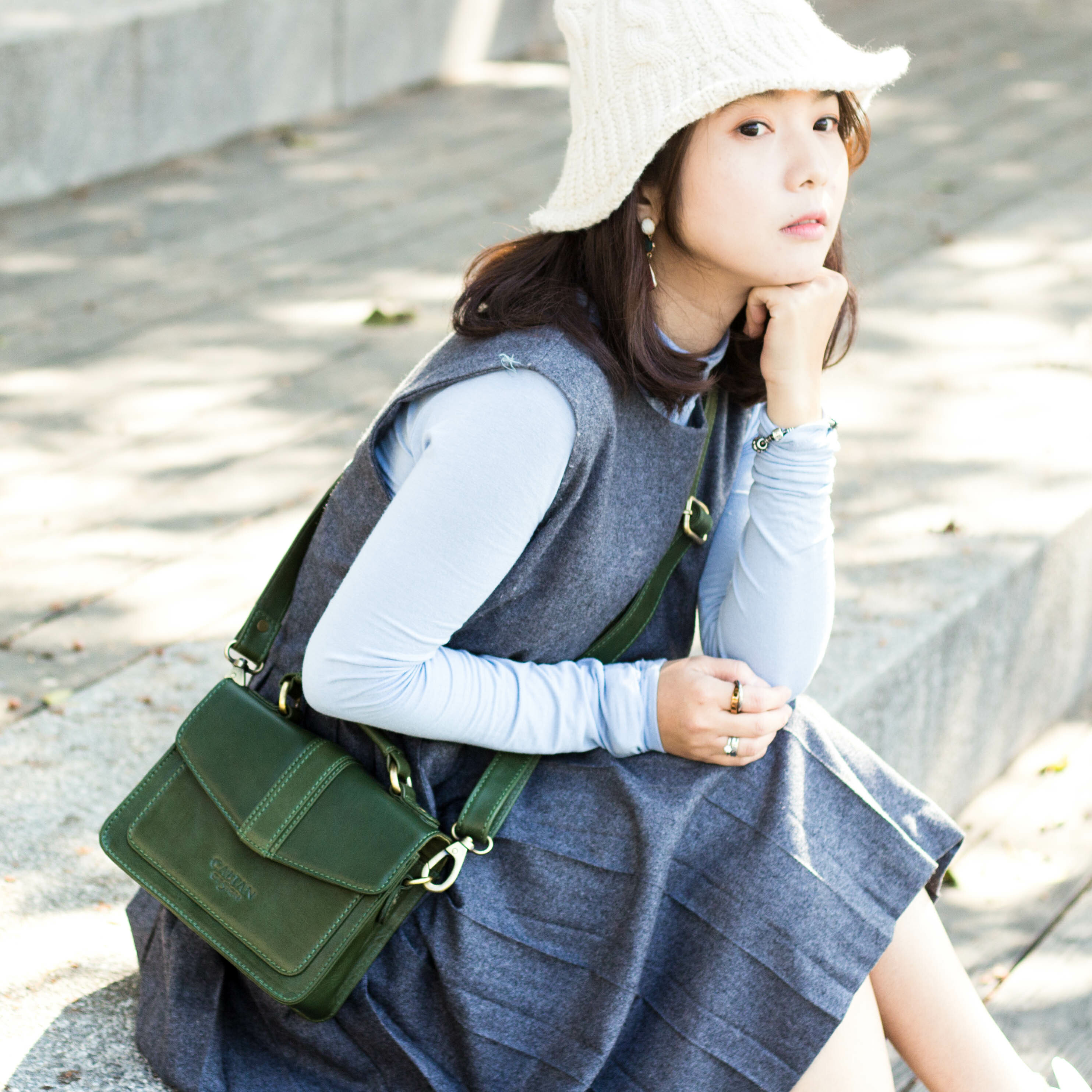 女孩揹著CALTAN真皮小方包