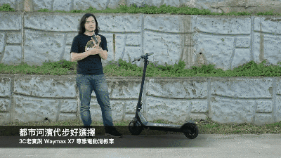 一位男生騎著黑色的Waymax X7電動滑板車在河濱公園移動