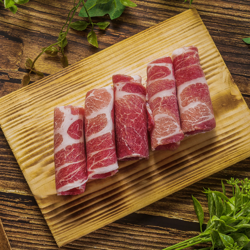 木砧板上捲成筒狀的山野豚梅花火鍋肉片，肉裡可見油花