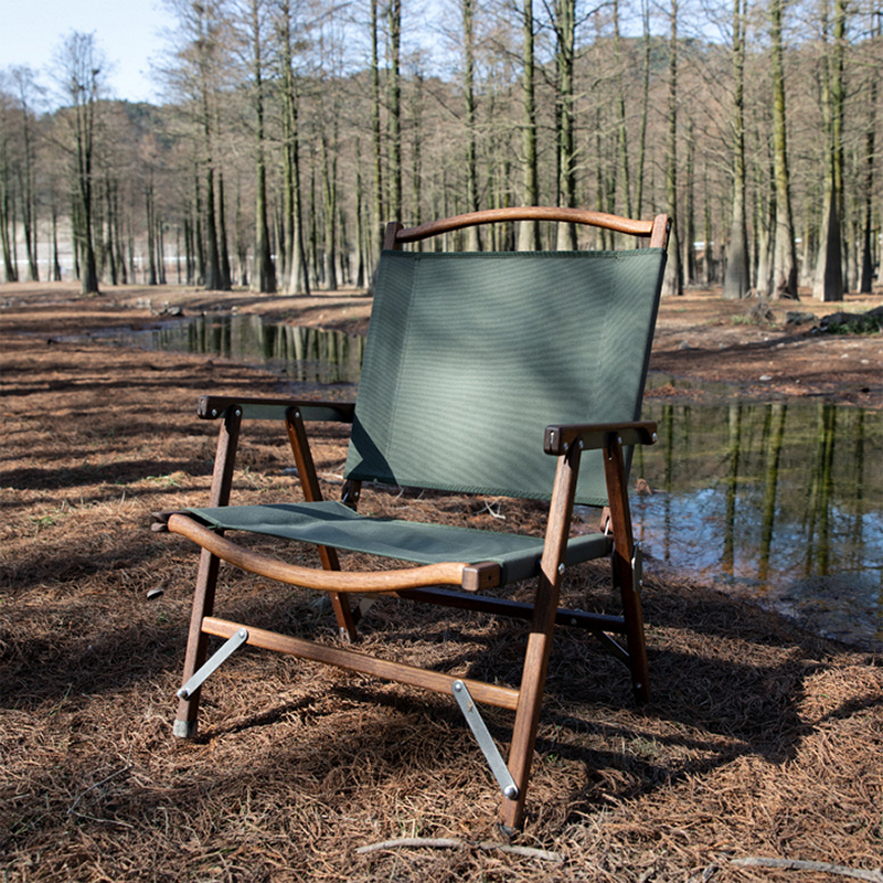 在森林中露營，黑色的椅布與原木色的椅子。露營用品與露營推薦的露營裝備都在露營中毒本鋪買。