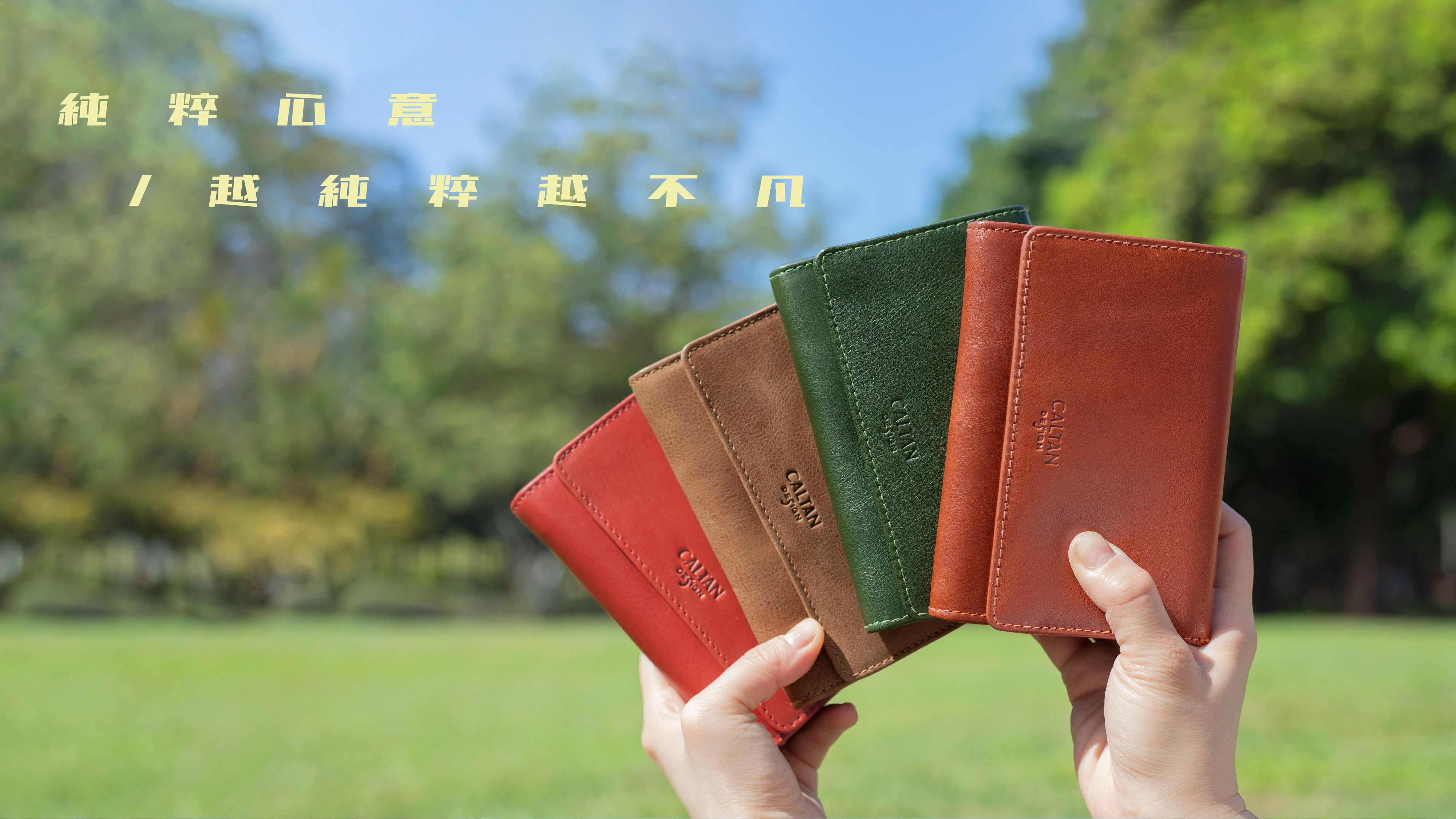 一雙手拿著四個中型真皮夾