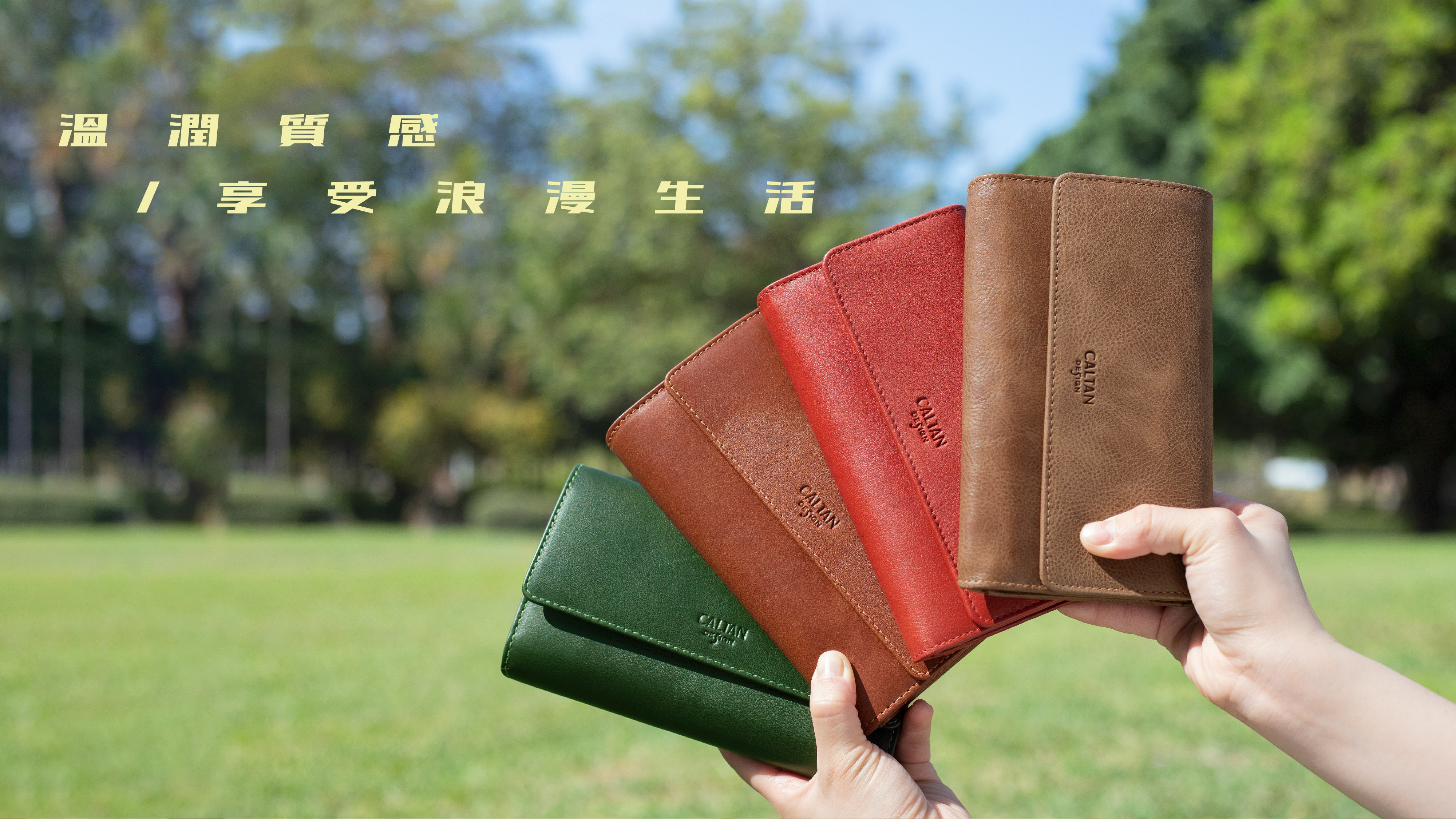 一雙手拿著四個長形真皮夾