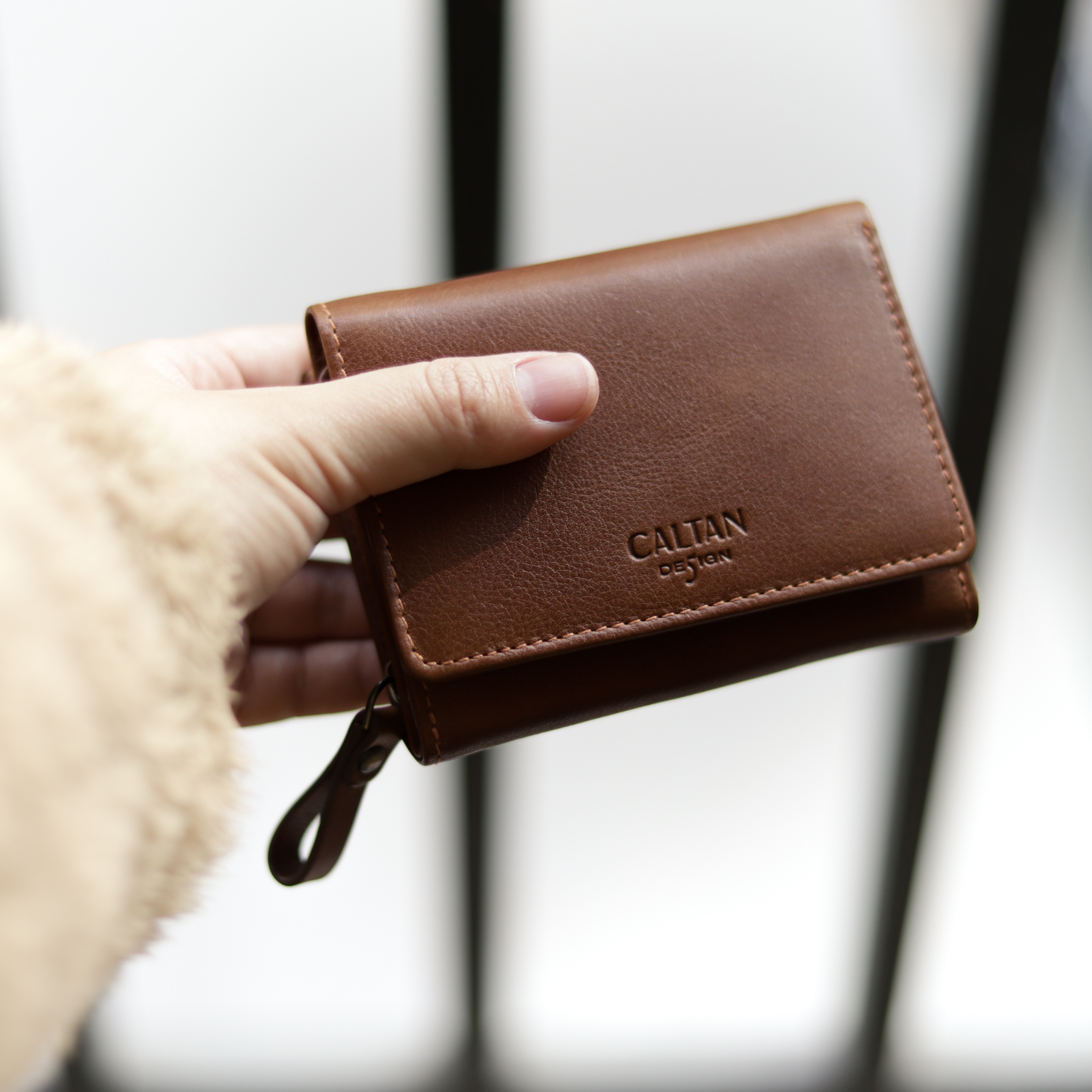 手上拿著caltan真皮短夾075021