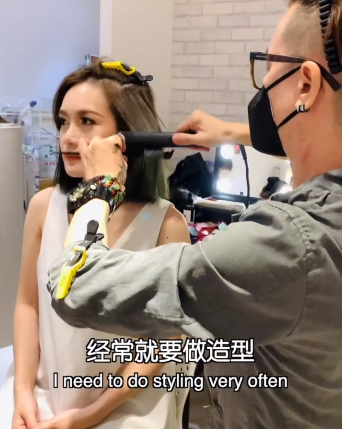 一位发型设计师正在为马来西亚艺人小薇薇做头发造型。