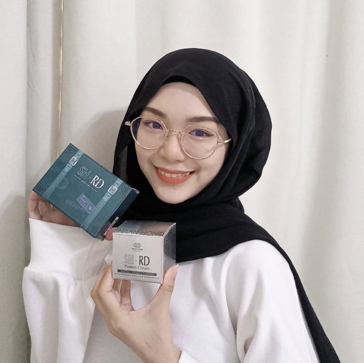 一位带着头巾的穆斯林网红手中拿着SH-RD蛋白质护发霜以及一盒绿色盒子的体验组，说明着产品都有清真等严格认证，品质安全有保障。