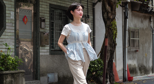 女生在戶外著 Tshirt 搭小背心和寬褲