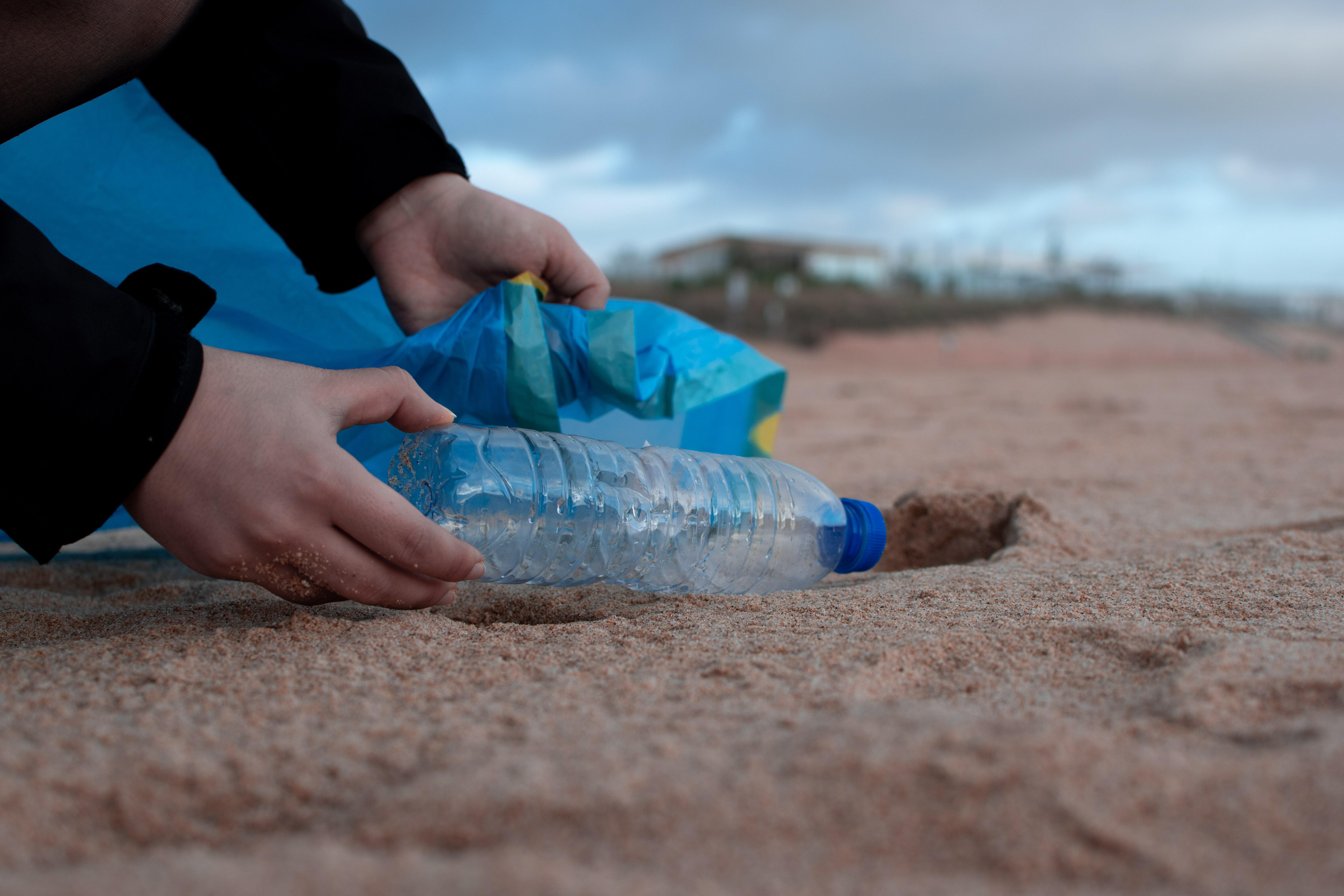 Picking up plastic bottle on beach