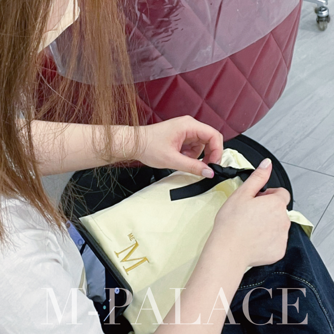 M-PALACE沙龍店的設計師正在看MEM組合附贈的束口袋